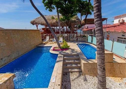 a swimming pool with two palm trees next to a building at TAMA Hotel Santa Marta in Santa Marta
