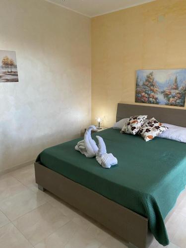 a bedroom with a bed with a towel animal on it at Casa Doppia G in Oliveri