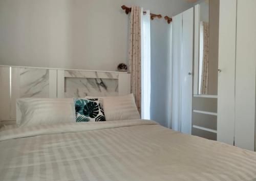a bedroom with a white bed with a pillow on it at Sunshine Rest Resort in Ubon Ratchathani