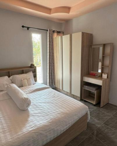 a bedroom with a large bed and a window at Sunshine Rest Resort in Ubon Ratchathani