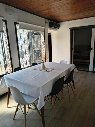 a table with chairs and a white table cloth on it at Aloha in Chacabuco
