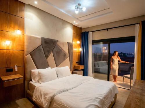 a woman standing in a hotel room with a bed at New dream home in Fez