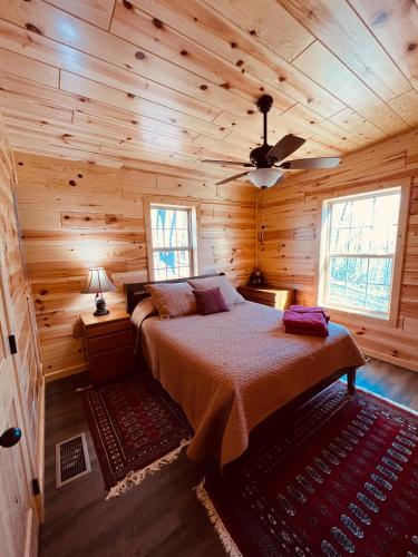 a bedroom with a bed in a wooden cabin at Hedgehog Hill Cabin-Helen Hideaway in Clarkesville