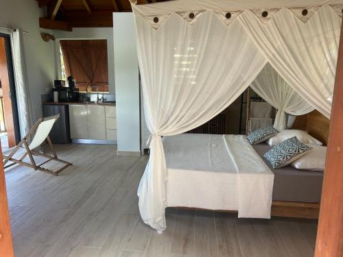 a bedroom with a bed with a canopy at Sukha Lodge in Le Moule