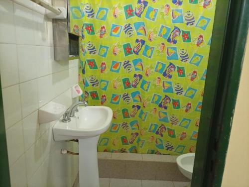 a bathroom with a sink and a yellow shower curtain at Finca Re Mar 1 in Santa Ana