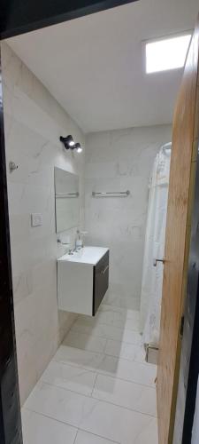 a white bathroom with a sink and a mirror at Apartament for 2 people - Jorge Two in Adrogue
