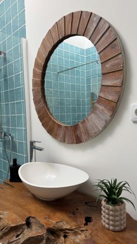 a bathroom with a wooden mirror and a white sink at Quinta Maria Cotovia in Porto Covo
