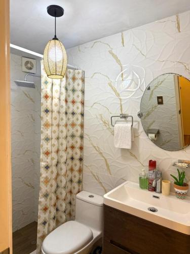 a bathroom with a toilet and a sink and a mirror at City Center Lima in Lima
