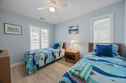 a bedroom with two beds and a ceiling fan at Tranquility By The Sea-Oceanside Condo in Salter Path