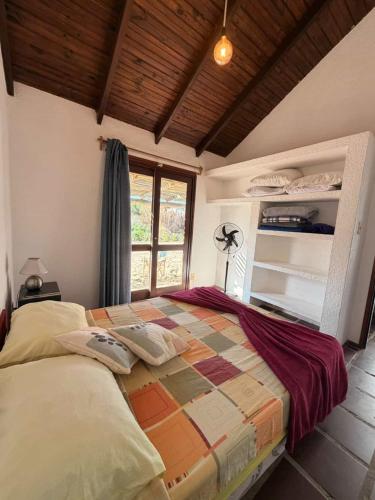 a bedroom with a large bed in a room with a window at Mar y Sal in Punta Del Diablo