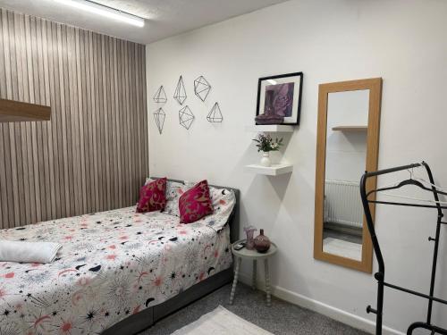 a bedroom with a bed and a mirror at Private Apartment in Oldham