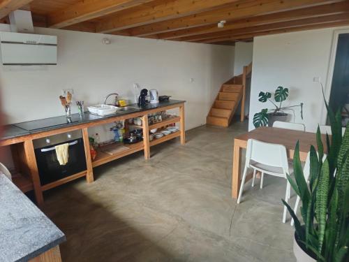 a kitchen and dining room with a table and a table and chairs at T1 com Vista Mar em Sao Roque do Pico Residências Requinte in São Roque do Pico