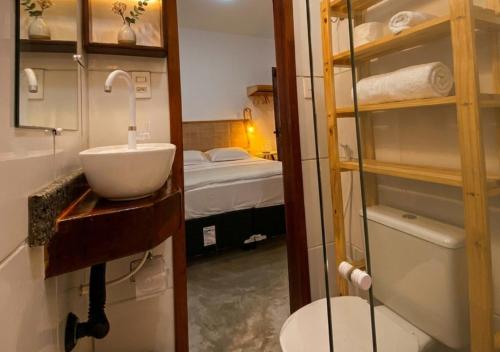 a bathroom with a sink and a toilet and a bed at Pousada Nativa Jeri in Jericoacoara
