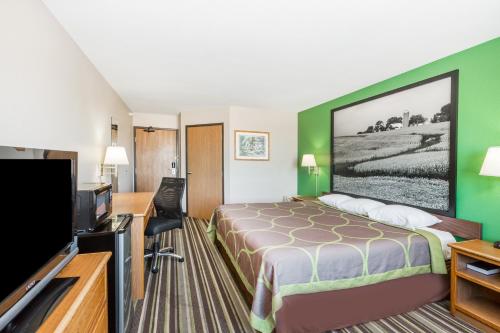 a hotel room with a bed and a flat screen tv at Super 8 by Wyndham Sioux City South in Sioux City