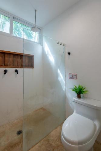 a bathroom with a toilet and a glass shower at Private Jungle Villa with Full Kitchen & Pool Access in Tulum