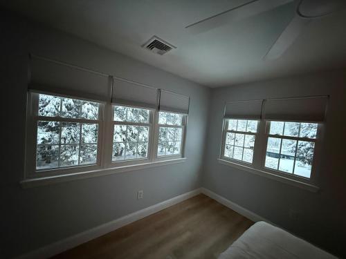 an empty room with three windows and a bed at GorgeousWestwood in Westwood