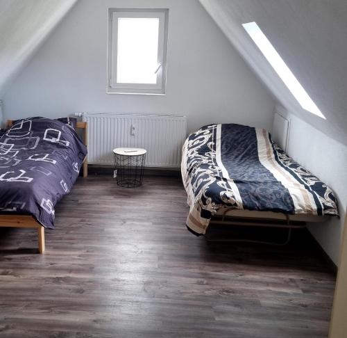 ein Schlafzimmer mit zwei Betten und einem Tisch in der Unterkunft Mony land in Netphen