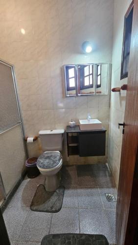 a bathroom with a toilet and a sink at Casa da Passagem in Cabo Frio