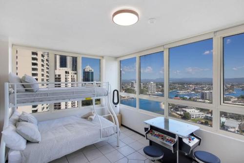 a bedroom with a bunk bed and large windows at Salt & Sky Arcade - Sleeps 12 in Gold Coast