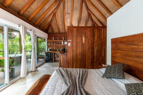 a bedroom with a bed in a room with windows at Luxury Jungle Suite with Private Jacuzzi & Cenote Pool View in Chemuyil