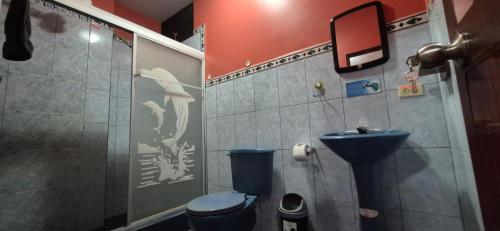 a bathroom with a blue toilet and a sink at Casa de Lewis in San Cristóbal