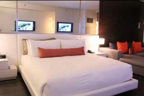 a bedroom with a large white bed and a couch at Palms Place Condo with strip view in Las Vegas