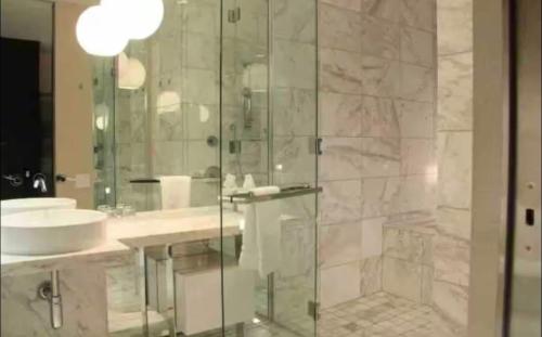 a bathroom with a glass shower and a sink at Palms Place Condo with strip view in Las Vegas
