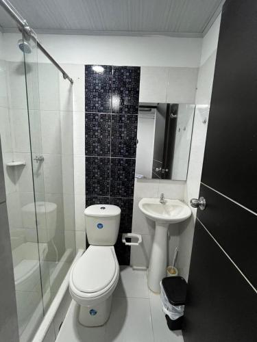 a bathroom with a toilet and a sink and a shower at El Rincon de Teresita in Villavicencio