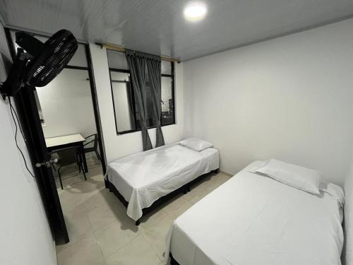 a room with two beds and a desk in it at El Rincon de Teresita in Villavicencio