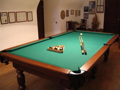 a green pool table with a ball and cues at Zamek Dobra in Oleśnica