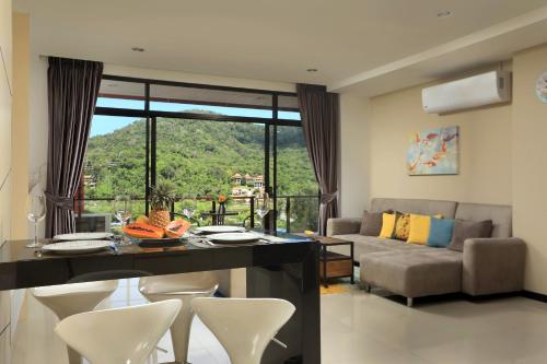 a living room with a table and chairs and a couch at Nai Harn Condominium in Nai Harn Beach