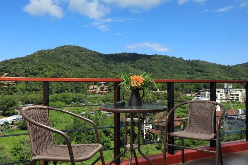 a balcony with two chairs and a table with a view at Nai Harn Condominium in Nai Harn Beach