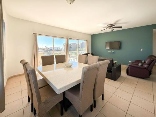 a dining room with a table and chairs and a couch at Stylish Condo Beach & Pool Access E202 in Puerto Peñasco