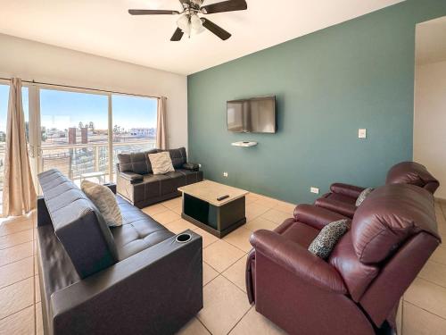 a living room with two couches and a tv at Stylish Condo Beach & Pool Access E202 in Puerto Peñasco