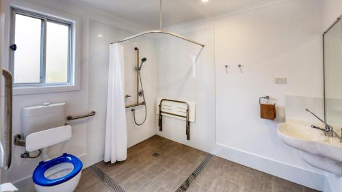 a bathroom with a shower and a toilet and a sink at Cunnamulla Tourist Park in Cunnamulla