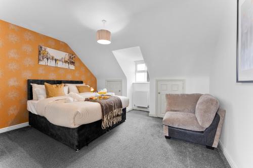 a bedroom with a large bed and a chair at 3-Bedrm, Parking, Soccer Table, Sleeps 7 in Cannock