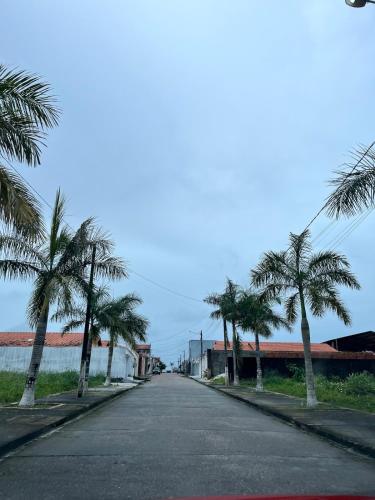 an empty street with palm trees on the side of the road at Casa completa em Bragança in Bragança