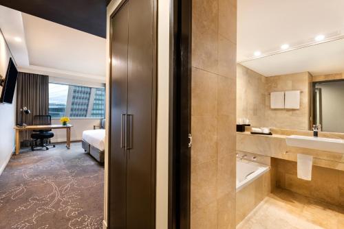a hotel room with a bathroom with a sink at PARKROYAL Darling Harbour, Sydney in Sydney