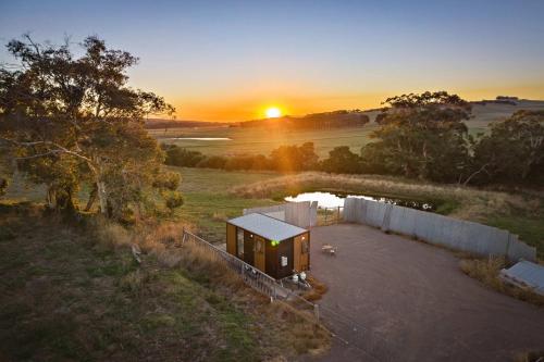 an overhead view of a house with the sunset in the background at Rivergum Lodge by Tiny Away in Scotts Creek