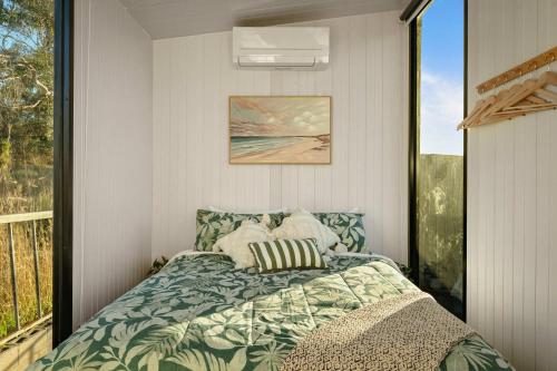 a bedroom with a bed and a window at Rivergum Lodge by Tiny Away in Scotts Creek