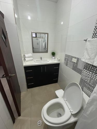 a white bathroom with a toilet and a sink at Boutique Exclusive Stay in Baños