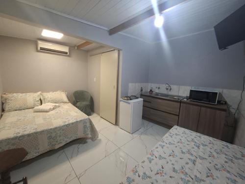 a bedroom with a bed and a sink in it at Small and cozy in Ijuí