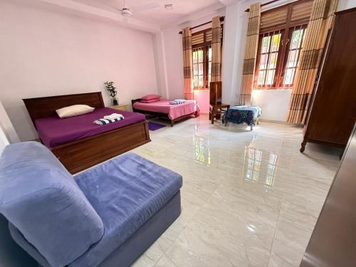 a living room with two beds and a couch at Arumathi Villa in Bentota
