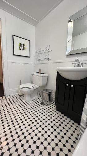 a white bathroom with a sink and a toilet at Maison Quartier du Musée in Gatineau