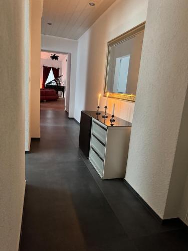 a room with a vanity with a mirror and a hallway at Red Silence I Design Suite im Koblenz in Bendorf