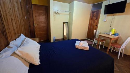 a hotel room with a bed with a tray with a candle on it at Hostal La Casa del Sol in Juliaca