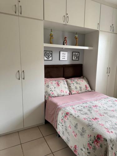 a small bedroom with a bed and white cabinets at Encanto Parangaba in Fortaleza