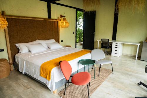 a bedroom with a large bed and two chairs at Villajesu Villeta in Villeta