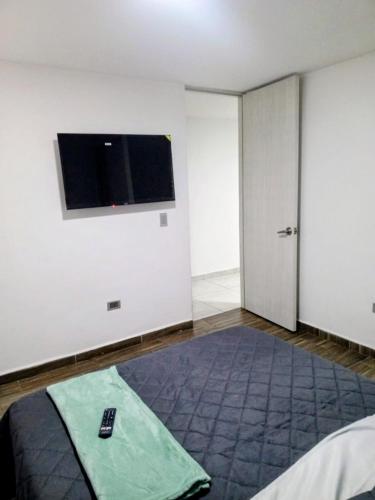 a bedroom with a tv on the wall and a bed at Dónde Habita in Circasia