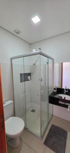 a bathroom with a glass shower and a toilet at Flats Paris in Lagoa Santa